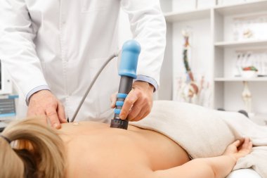 Extracorporeal Shockwave Therapy ESWT cerrahi olmayan tedavi. Boyun ve sırt kasları için fizik tedavi, şok dalgalarıyla omurga. Ağrı kesici, normalleşme ve yenilenme, canlandırma işlemleri, canlandırma süreci.