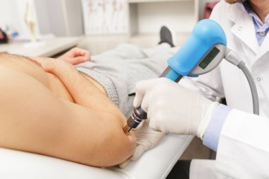 Extracorporeal Shockwave Therapy ESWT etkili cerrahi olmayan tedavi. Şok dalgalarıyla tenis dirseği için fizik tedavi. Ağrı kesici, normalleşme ve yenilenme, iyileşme sürecinin uyarılması.