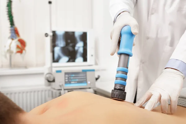 Extracorporeal Shockwave Therapy ESWT cerrahi olmayan tedavi. Boyun ve sırt kasları için fizik tedavi, şok dalgalarıyla omurga. Ağrı kesici, normalleşme ve yenilenme, canlandırma işlemleri, canlandırma süreci.