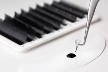 Kirpik uzatma aletleri. Sahte kirpik kiti. Kirpik uzatma için aksesuarlar. Kirpik yapıştırıcısı ve kavisli cımbız. Kirpik uzatma işlemi