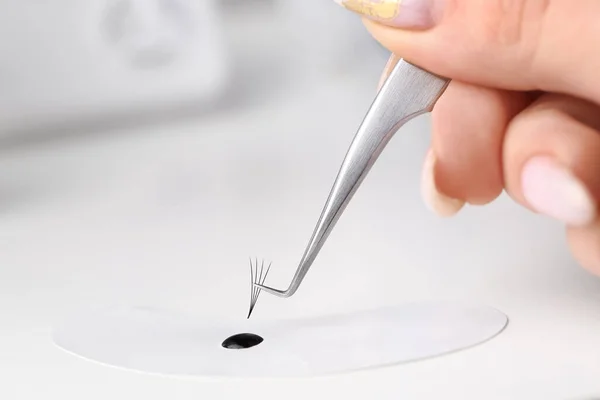 Kirpik uzatma aletleri. Sahte kirpikler. Kirpik uzatma için aksesuarlar. Kirpik yapıştırıcısı ve kavisli cımbız. Kirpik uzatma işlemi