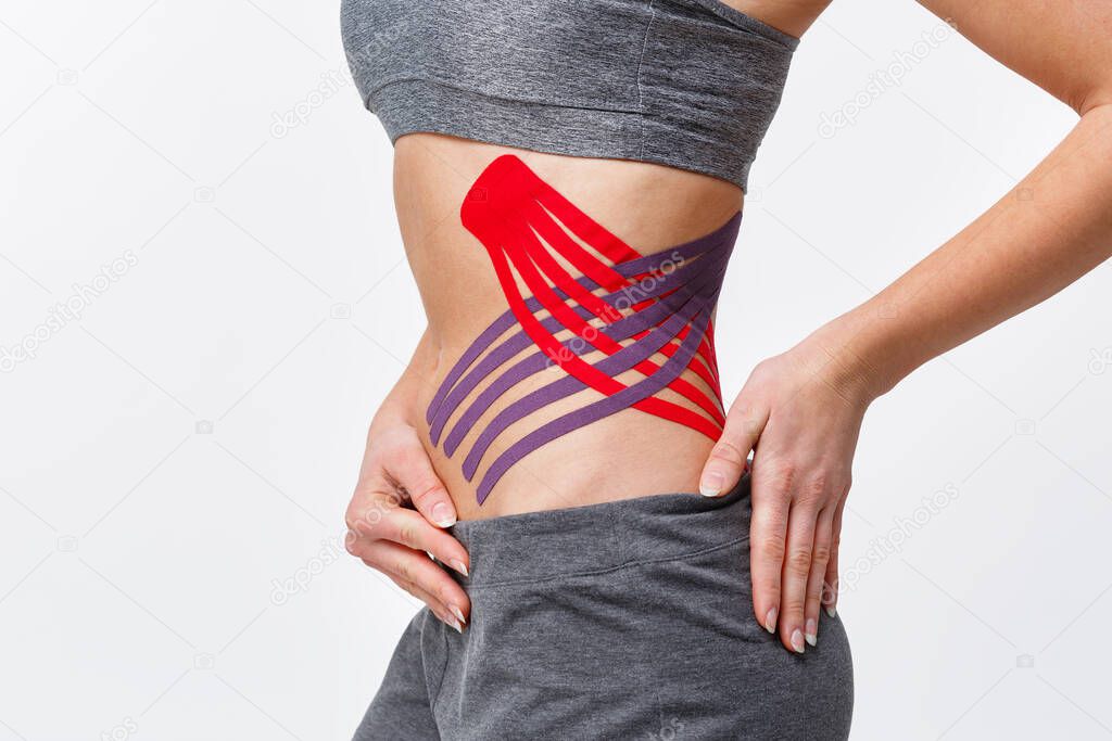 Weight loss concept. Kinesiology taping.Anti-cellulite procedure for slim belly.Close up view of kinesiology tape on patient tummy.Fat lose, cellulite removal, sport physical therapy,recovery concept