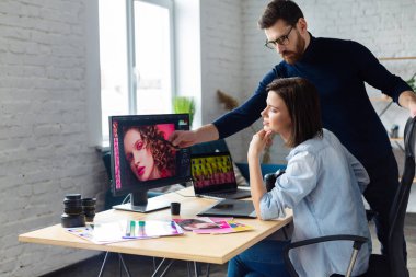 Profesyoneller, fotoğrafçı ve rötuş ustası. Grafik tabletinden resimler alınıyor. Profesyonel bir fotoğraf stüdyosunda takım çalışması.