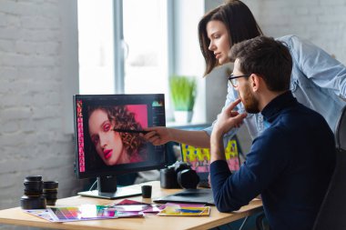 Profesyoneller, fotoğrafçı ve rötuş ustası. Grafik tabletinden resimler alınıyor. Profesyonel bir fotoğraf stüdyosunda takım çalışması.