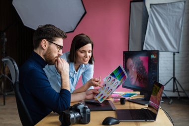 Profesyoneller, fotoğrafçı ve rötuş ustası. Grafik tabletinden resimler alınıyor. Profesyonel bir fotoğraf stüdyosunda takım çalışması.