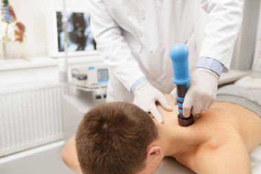 Extracorporeal Shockwave Therapy ESWT cerrahi olmayan tedavi. Boyun ve sırt kasları için fizik tedavi, şok dalgalarıyla omurga. Ağrı kesici, normalleşme ve yenilenme, canlandırma işlemleri, canlandırma süreci.