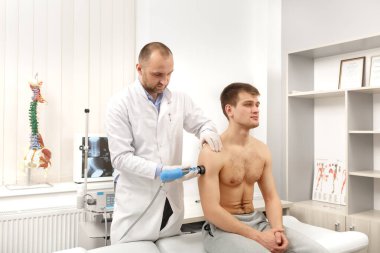 Extracorporeal Shockwave Therapy ESWT.Efftive non-cerrahi tedavi. Omuz için şok dalgalı fizyoterapi. Ağrı kesici, normalleştirme ve yenilenme, iyileşme sürecinin uyarılması.