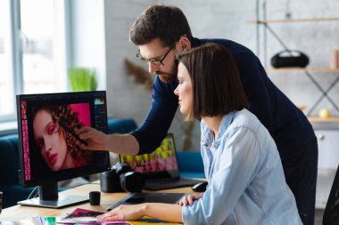 Ofiste dizüstü bilgisayar, monitör, grafik çizim tableti ve renk paleti ile çalışan fotoğrafçı ve grafik tasarımcısı. Reklam ajansında fikirleri tartışan bir ekip yaratmak. Görüntüler alınıyor. Takım çalışması.