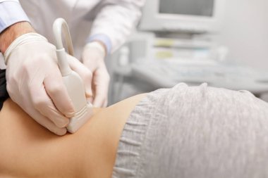 Terapist, hastalarının ultrason muayenesi yapıyor. Ofisinde sırt üstü yatıyor. Klinikte ultrason taramasını geçen genç bir kadın. Doktorlar çalışır. Tıbbi araştırma