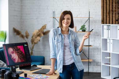 Ofiste dizüstü bilgisayar, monitör, grafik çizim tableti ve renk paleti ile çalışan grafik tasarımcısının portresi. Özel programda resimler alınıyor. Fotoğraf stüdyosunda iş yeri alınıyor. Yaratıcı ajans