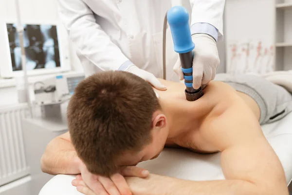 Extracorporeal Shockwave Therapy ESWT.Non-surgical treatment.Physical therapy for neck and back muscles,spine with shock waves.Pain relief, normalization and regeneration,stimulation healing process — Stock Photo, Image