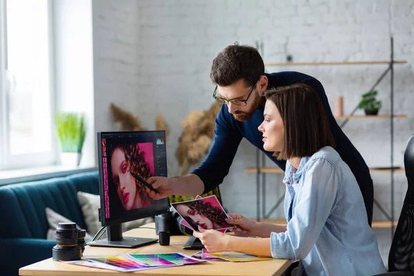 Fotograf i grafik pracujący w biurze z laptopem, monitorem, tabletem graficznym i paletą kolorów. Tworzenie zespołu omawiającego pomysły w agencji reklamowej. Retuszowanie obrazów. Praca zespołowa — Zdjęcie stockowe