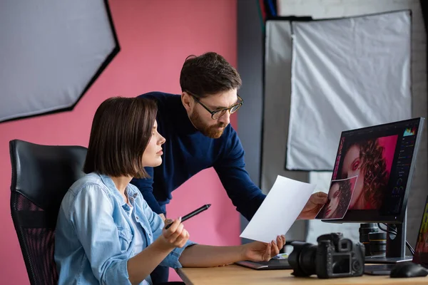 Fotograf och grafisk formgivare arbetar på kontoret med laptop, monitor, grafisk ritplatta och färgpalett. Skapa team diskuterar idéer i reklambyrå. Retuscherar bilder. Lagarbete — Stockfoto