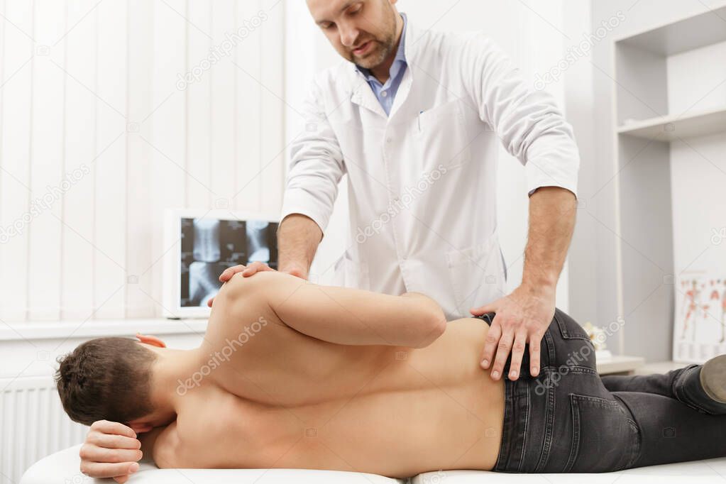 Manual therapist doing manual adjustment on patients spine. Chiropractic, osteopathy, manual therapy, post traumatic rehabilitation, sport physical therapy. Alternative medicine, pain relief concept