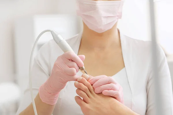 의료 페디큐어 시술을 받고 있는 환자 , podiatrist.Professional hardware pedicure 를 방문하는 환자, 전기 기계공을 사용하는 전문 하드웨어 페디큐어 특수 전기 장치를 사용하여 발을 페닝하는 SPA salon.Podiatry Clinic 의 발 치료 — 스톡 사진