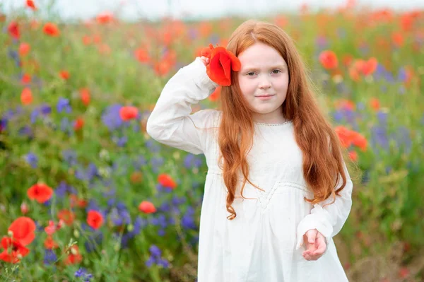 彼女の髪のポピーと立っている赤毛の甘い女の子 — ストック写真