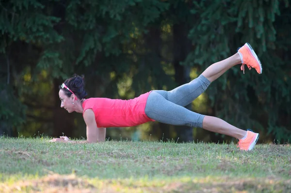 Menina bonita nova está envolvida em ioga, ao ar livre em um parque em s — Fotografia de Stock