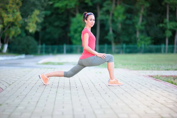 Jovem mulher fitness bonita faz exercícios de alongamento durante o spor — Fotografia de Stock