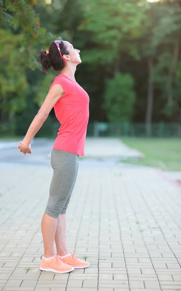 Vista de esportivo jovem mulher fazendo exercício matutino no parque — Fotografia de Stock
