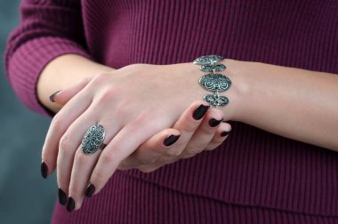 Close up women's hands with silver bracelet and ring on her fing clipart