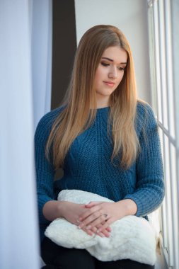 Penceresine bakarak mavi yün kazak kız