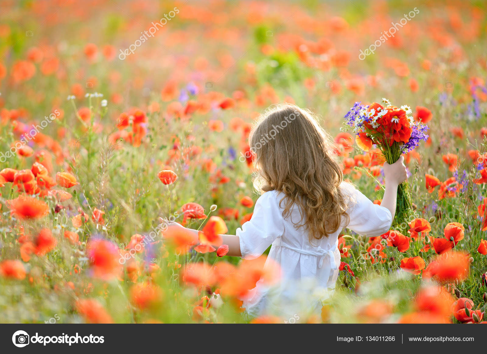 Happy child girl with field flowers running on meadow in summer — Stock Photo © sasapanchenko