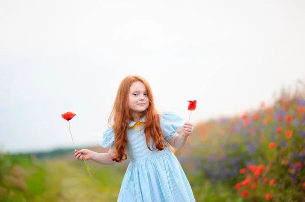 Portret szczęśliwy ruda dziewczyna z kwiatami maku w jej ręce. — Zdjęcie stockowe