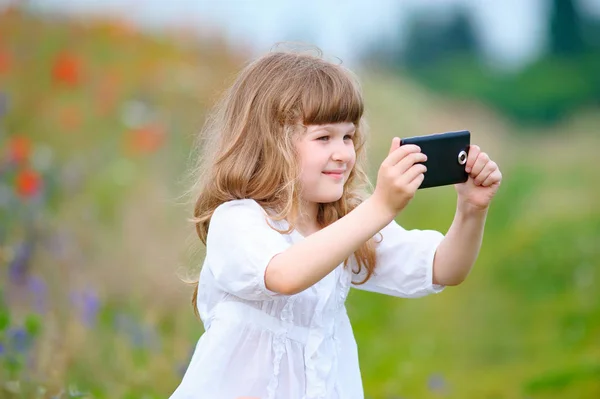 Mutlu küçük kız açık havada yürüyüş alarak Selfie ile cep telefonu — Stok fotoğraf