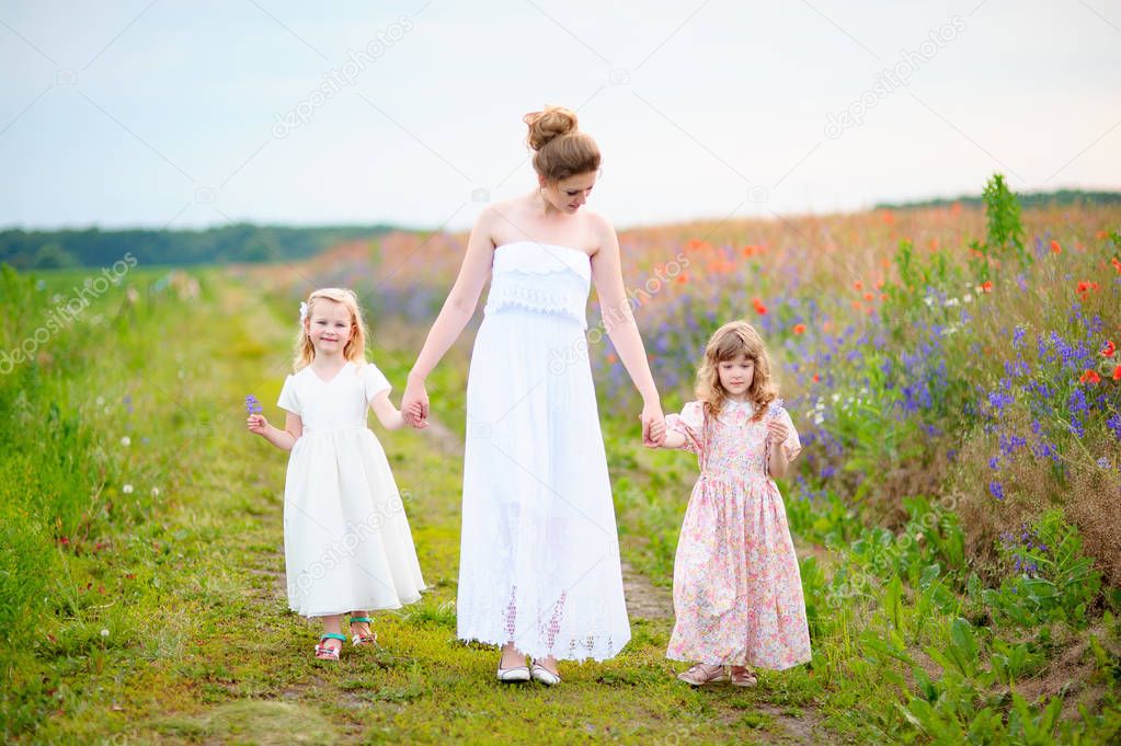 walking family through the spring field of wild flowers