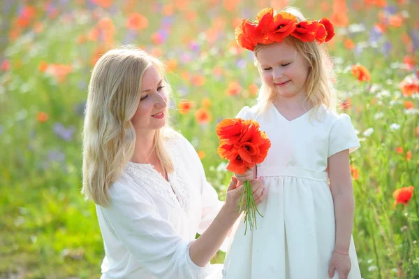 Little beautiful pretty girl and her mother with wild flowers  -