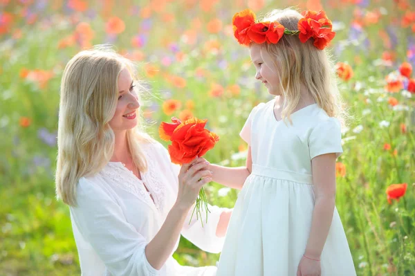 Pequena menina bonita dando uma flores para sua lua feliz — Fotografia de Stock