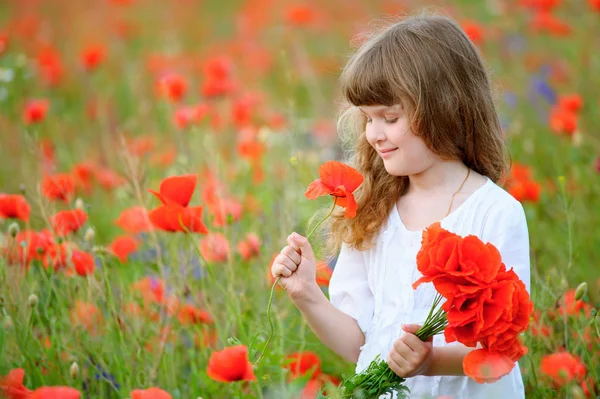 Süßes kleines Mädchen mit einem Strauß roter Mohnblumen genießt Outdoo — Stockfoto