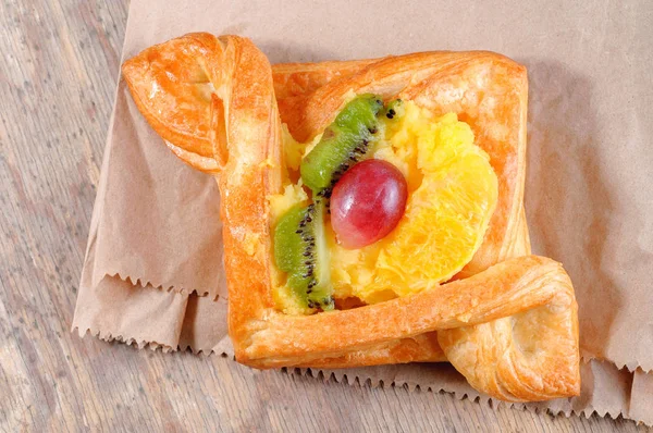 Pain au kiwi orange et raisins sur une vieille surface en bois — Photo