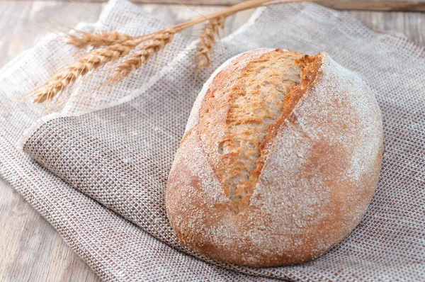 Pane appena sfornato di pane su un tovagliolo di lino, cibo su t d'annata — Foto Stock