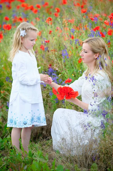 Jeune mère et enfant fille en robes blanches sur prairie d'été . — Photo