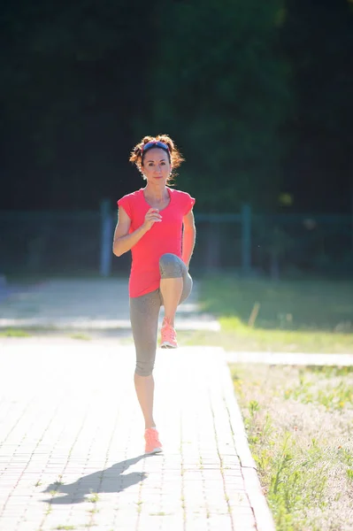 A desportista está a alongar-se antes de correr. Aptidão e estilo de vida — Fotografia de Stock