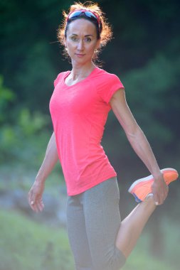 Atlet Jogger uzanan bacaklar açık, hazırlanması için çalıştırın. Kadın