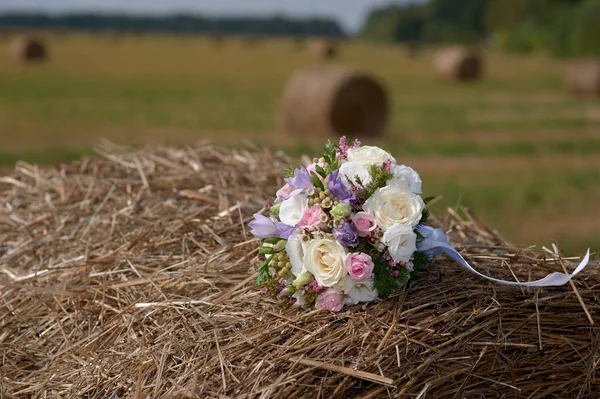 Beautiful bridal bouquet lying on the haystack — Stock Photo, Image