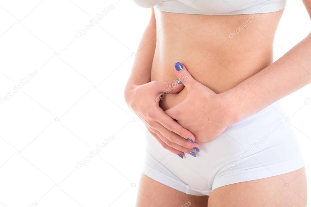 Midsection of female body suffering from stomach ache over white