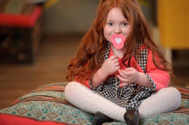 Şirin çocuk kız holding dudak şeklinde oyuncak kalp ile gülümseyen