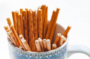 bir fincan beyaz arka plan üzerinde closeup görünümü bir simit sopa