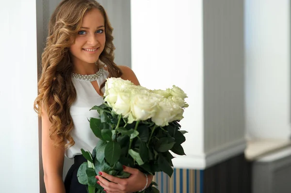 Щасливе довге волосся молода дівчина з букетом білих троянд. Внутрішні — стокове фото