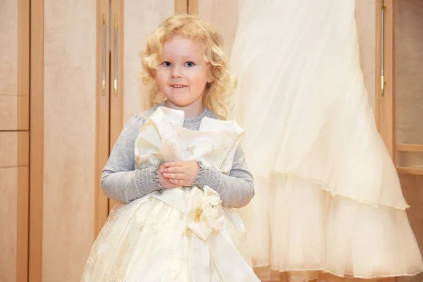 어린 소녀는 그녀의 어머니의 신부 드레 근처 웨딩 드레스 즐길 — 스톡 사진