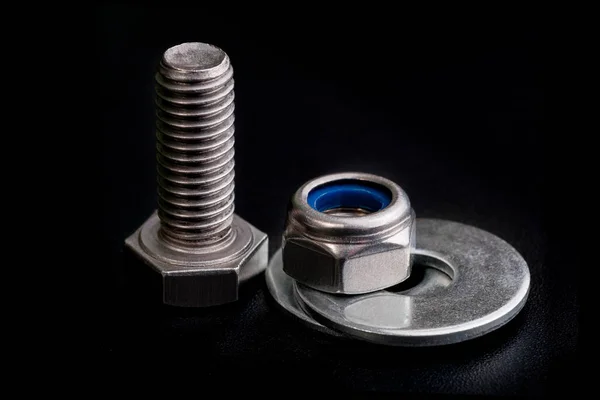 Stainless steel bolt with a nut and washers on black — Stock Photo, Image