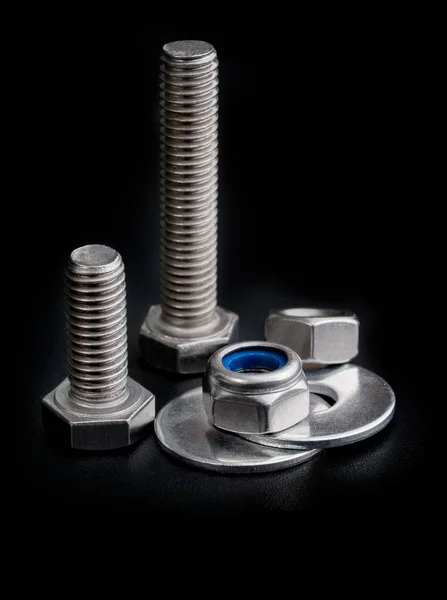 Bolts nuts and washers. Closeup screw tools on black background — Stock Photo, Image