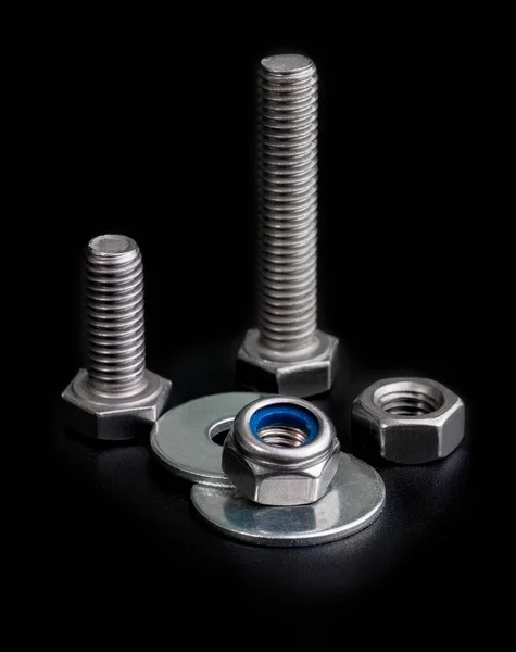 Bolts with a nuts and washers isolated on black background — Stock Photo, Image