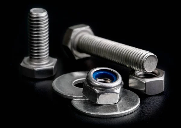 Screw isolated on the black backgrounds. Nuts with bolts and was — Stock Photo, Image