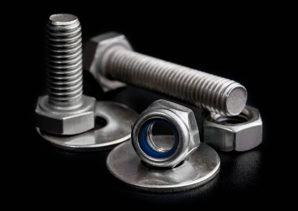 Steel bolts and nuts with washers on black background close-up — Stock Photo, Image