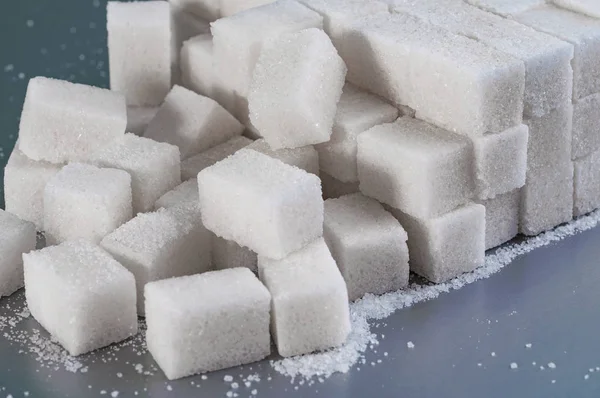 Azúcar granulado blanco sobre un fondo gris — Foto de Stock
