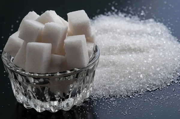 Raffinierter Zucker und Kristallzucker auf schwarzer Oberfläche — Stockfoto